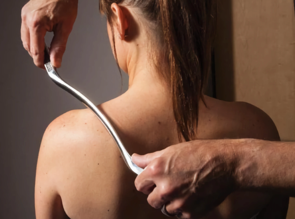 Instrument-assisted bodywork across the upper back