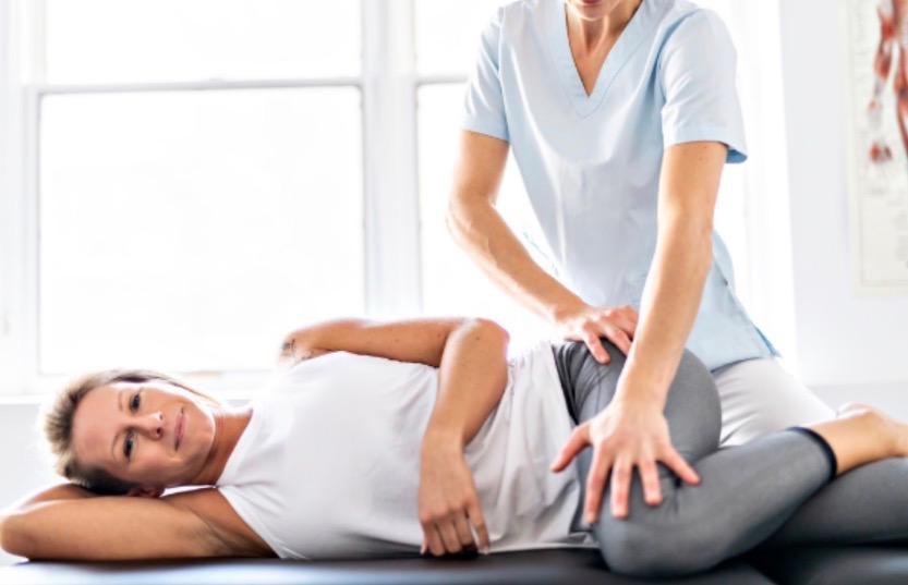 Practitioner guiding a supported side-lying stretch